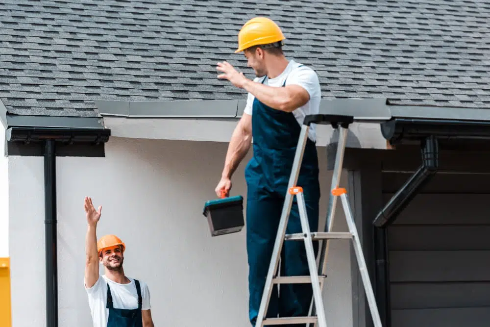 Deux technicien se saluant et un sur un escabeau